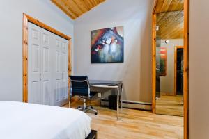 a bedroom with a desk and a bed and a chair at M Lofts in Calgary