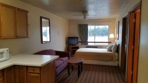 um pequeno quarto de hotel com uma cama e um sofá em Inn of the Pines em Adams