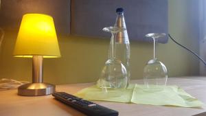 a desk with a lamp and two wine glasses on it at myHome in Gießen