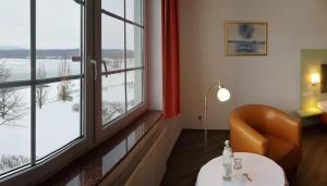 Habitación con mesa, silla y ventana en Hotel Haus am See en Olbersdorf