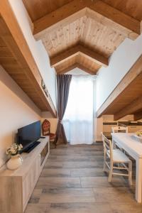 ein Wohnzimmer mit Holzdecken und einem großen Fenster in der Unterkunft ALICE HOME in Turin