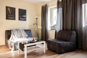 a living room with a couch and a chair at Apartamenty KDN na Rysiej in Katowice