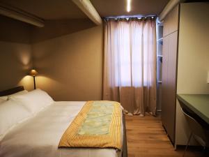 a small bedroom with a bed and a window at Luxury Langhe Loft in La Morra
