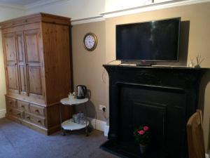 ein Wohnzimmer mit einem Kamin und einem Flachbild-TV in der Unterkunft The Crown Bar & Guesthouse in Broadstairs