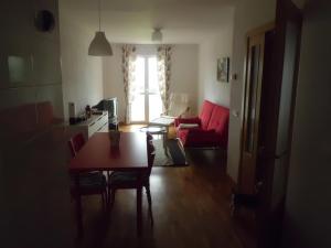 ein Wohnzimmer mit einem Tisch und einem roten Sofa in der Unterkunft Apartamento Rio Lavilla in Castañares de Rioja