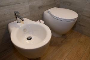 a bathroom with a white toilet and a sink at La Vigne de Papagran in Aosta