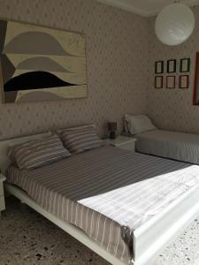 Appartamento Acquamarina في مارينا دي سيسينا: غرفة نوم بسرير كبير وأريكة