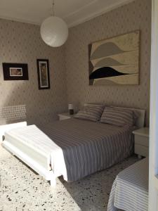 Appartamento Acquamarina في مارينا دي سيسينا: غرفة نوم بسرير ودهان على الحائط