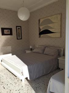 a bedroom with a bed and a painting on the wall at Appartamento Acquamarina in Marina di Cecina +29 photos