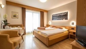 a hotel room with two beds and a television at Residence Sas Vanna in La Villa