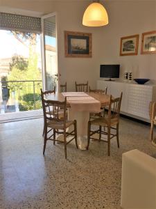 ein Esszimmer mit einem Tisch, Stühlen und einem TV in der Unterkunft Appartamento Acquamarina in Marina di Cecina