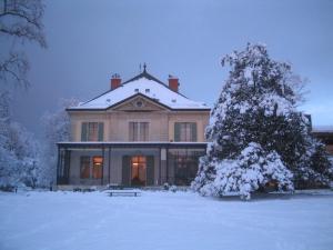 uma casa com uma árvore de Natal na neve em Le Cénacle em Genebra