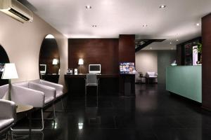 Eine Lobby mit einer Bar mit Stühlen und einem Fernseher in der Unterkunft Exe Suites Reforma in Mexiko-Stadt