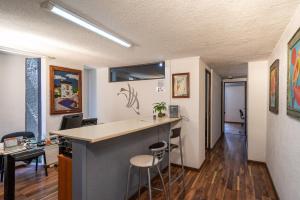 a kitchen with a counter and stools in a room at Hotel delf-inn in Cuernavaca