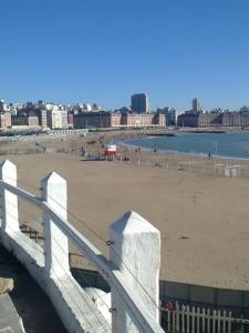 uma vista para uma praia com uma cerca branca em CHALET FALUCHO em Mar del Plata