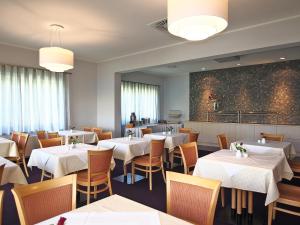 a dining room with white tables and chairs at Hotel Haus am See in Olbersdorf