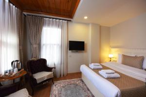 A bed or beds in a room at Elyka Hotel