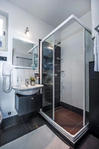 uma casa de banho com uma cabina de duche em vidro e um lavatório. em Guesthouse Bellavista em Rovinj
