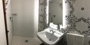 a white bathroom with a sink and a mirror at Viola Borgia in Florence