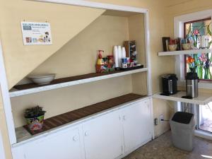 a kitchen with white cabinets and a shelf at Oasis Inn and Suites in Santa Barbara