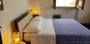 een slaapkamer met een bed met een blauwe deken en een raam bij Casa Vacanze LELUPE in Sant'Agnello