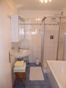 y baño con lavabo, ducha y bañera. en Schwarzwald-Ferienwohnungen Begert, en Baiersbronn