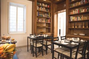 una sala da pranzo con tavoli, sedie e librerie di Fourooms - Bari Sparano a Bari