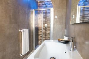łazienka z białą wanną i oknem w obiekcie Fourooms - Bari Sparano w mieście Bari +37 zdjęć