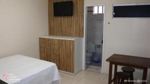a bedroom with a bed and a television and a bathroom at Hotel Pousada Ludovicense in São Luís