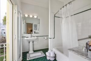 a white bathroom with a sink and a shower at Parker Guest House in San Francisco