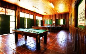 um quarto com uma mesa de bilhar num piso em azulejo em Hotel Fazenda Floresta Negra em Monte Verde