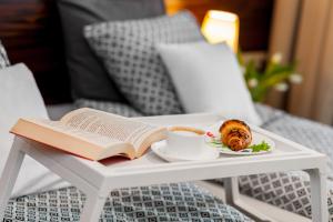 a book and a cup of coffee and a plate of food on a table at Apartamenty Black&White in Gdynia