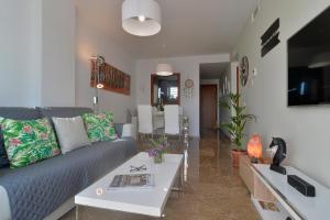 ein Wohnzimmer mit einem Sofa und einem Tisch in der Unterkunft Urbanización Galera Sun in Estepona