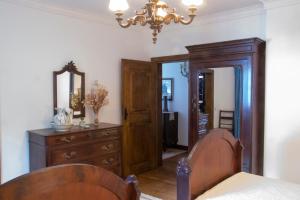 a bedroom with a wooden dresser and a mirror at Casa De Santa Comba in Cabeceiras de Basto +20 photos