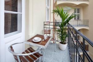 a patio area with a table and chairs and a balcony at Old Town - Dusni Apartments in Prague