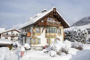 ein Haus ist mit Schnee bedeckt in der Unterkunft Villa St. Oswald in Seefeld in Tirol