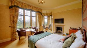 a bedroom with a bed and a desk and a fireplace at Kincraig Castle Hotel in Invergordon +17 photos