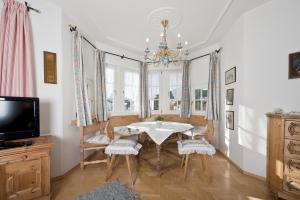 a dining room with a table and chairs and a tv at Villa St. Oswald in Seefeld in Tirol