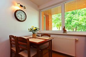 a dining room with a table and a clock on the wall at 2 kambarių apartamentai su virtuve, Trakų miesto centre in Trakai +35 photos