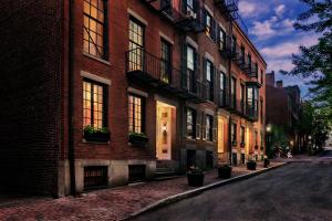 un bâtiment en briques avec des fenêtres et des plantes en pot dans une rue dans l'établissement Cozy Furnished Studio in Beacon Hill #4, à Boston