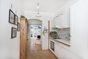 eine Küche mit weißen Schränken und einem Waschbecken in der Unterkunft Villa St. Oswald in Seefeld in Tirol