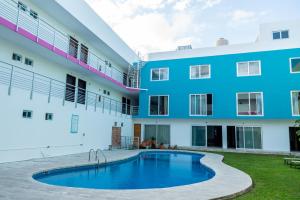 a swimming pool in front of a building at Hotel Playa Encantada in Playa del Carmen