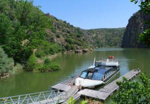 a boat parked at a dock on a river at Hostal Arribes del Duero in Fermoselle