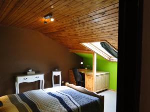 a bedroom with a bed and a desk and a window at Chambres d'hôtes des Ardennes in Porcheresse