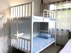 two bunk beds in a room with a window at Bann Rai Klai Weang Homestay in Ban Muang Chum