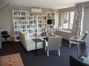 a living room with a book shelf filled with books at The Orchard in Whakamarama