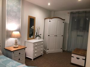 - une chambre avec un lit, une commode et une armoire dans l'établissement Hidden Treasure, à Newquay