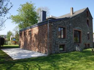 an external view of a brick building with a yard at Chambres d'hôtes des Ardennes in Porcheresse