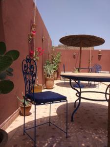 une terrasse avec une table, des chaises et un parasol dans l'établissement Riad Jakoura, à Marrakech