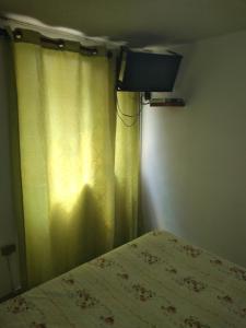 a bedroom with a television and a bed at Hotel Angamos in Santiago
